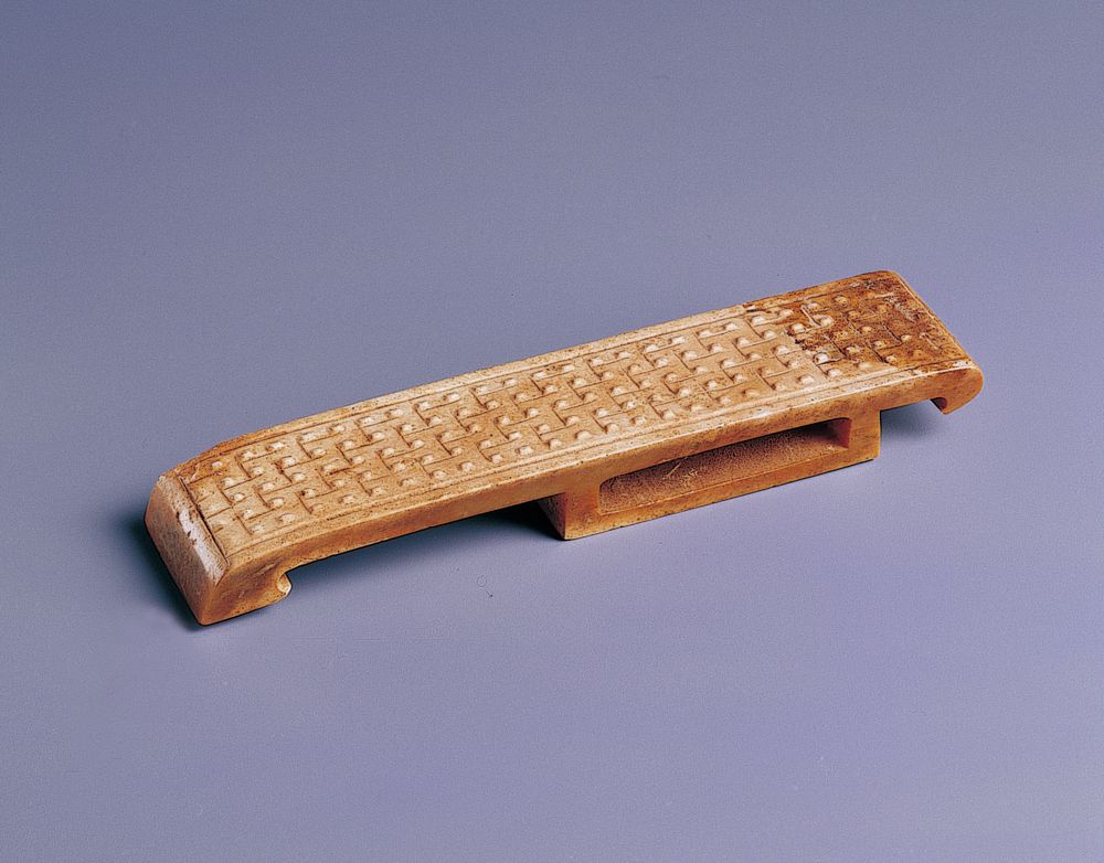 西漢 玉劍璏 此器以階梯式連線乳丁紋為飾，形成整齊的器面風格。（圖一）