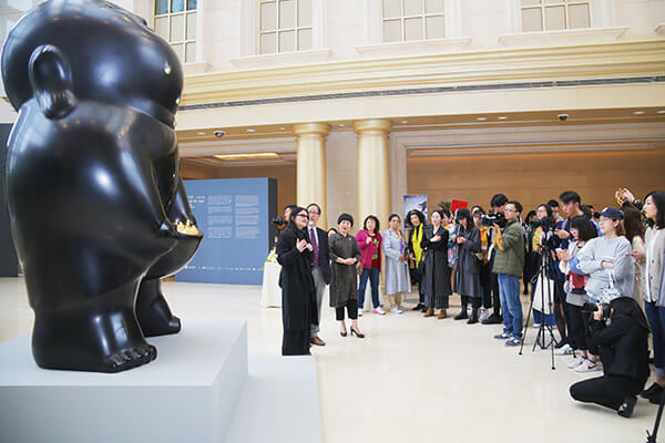 藝術家李真（左一）在展覽開幕當天為記者講述作品理念
