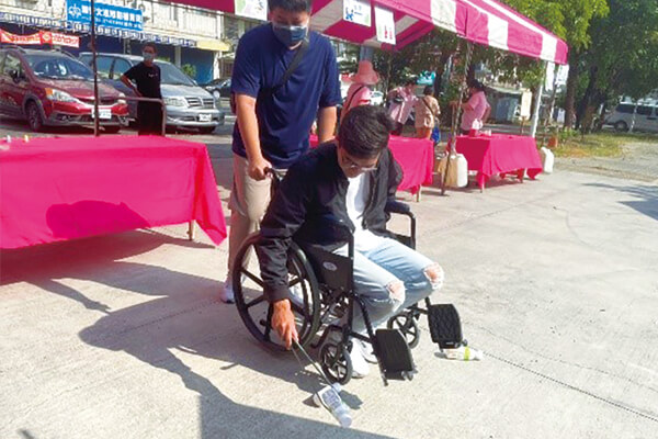 震旦志工協助現場闖關活動，也體驗輪椅行動的不便。