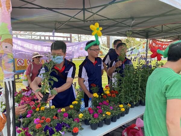 震旦志工協助發放小盆栽，讓會員們美化心中的綠地